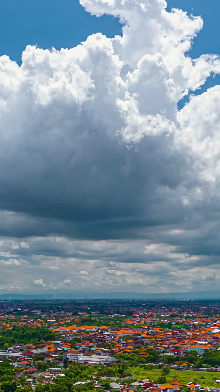 Drone hyperlapse of storm clouds over rooftops of Kuta Selatan in dramatic tropical scene