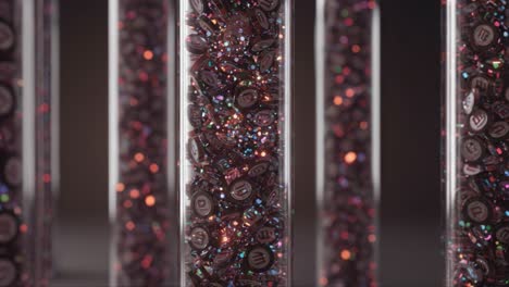 stunning close-up of vibrantly glittering candy capsules in transparent tubes, capturing the dazzling play of light and color in a unique arrangement