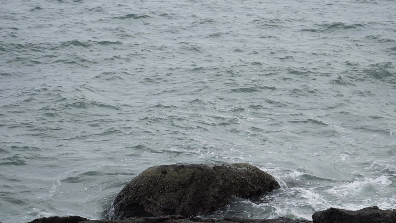변덕스러운 날 베트남의 바위투성이 해안선을 강타하는 파도, 정적인 샷
