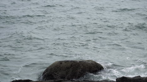 Ocean-waves-hitting-rocky-coastline-of-Vietnam-on-moody-day,-static-shot