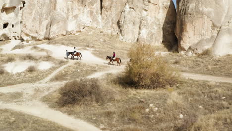 vacationist riding horses in goreme national park at summer in cappadocia, turkey