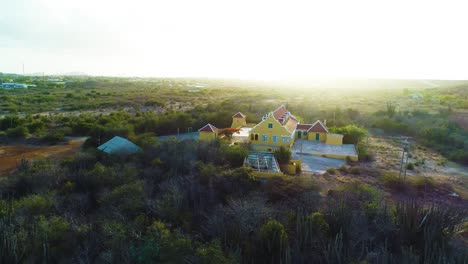 Casa-De-Campo-Con-Agujero-De-Letra-Que-Retrocede-A-Través-De-Extensos-Matorrales-Cubiertos-De-Maleza-Al-Atardecer