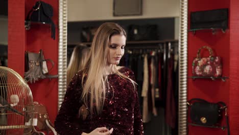 woman trying on a sequined dress in a clothing store