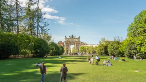 triumphal arch of peace in city park with people on lawn