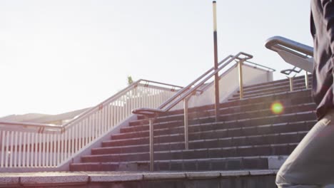 Low-section-of-asian-man-with-backpack-climbing-up-the-stairs-at-corporate-park