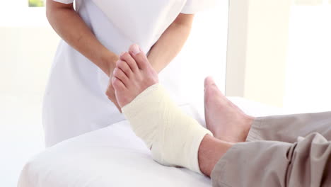 el médico vendando la pierna del paciente