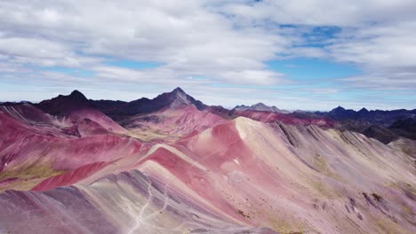 Toma-Aérea-Circular-De-Un-Valle-Con-Mineral-Rojo-En-La-Montaña-De-Siete-Colores,-Vinicunca