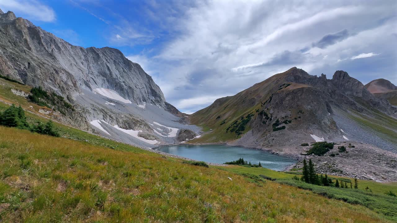 Summer late afternoon Capitol Lake Capitol Peak 14er wilderness landscape view blue sky clouds high elevation tundra snow melt pan Colorado Elk Mountain Range Aspen Snowmass Rocky Mountains