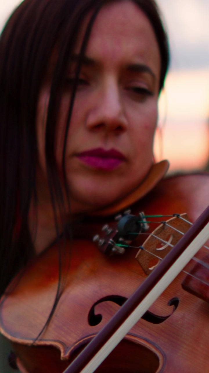 Woman Playing Violin Outdoors at Sunset