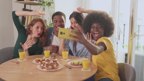 diverse friends taking fun selfies during breakfast