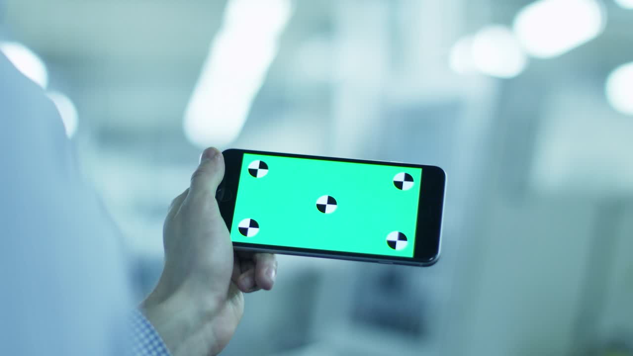 Worker is Using Smartphone with Green Screen in Landscape Mode in Factory