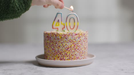 foto de estudio pastel de cumpleaños cubierto con adornos y velas celebrando el cuadragésimo cumpleaños encendido