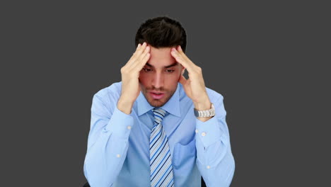 un joven empresario tiene dolor de cabeza.