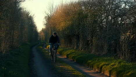 cyclist riding on a scenic country path during golden hour
