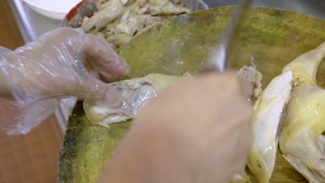 skillful hands of chef chopping chicken meat in restaurant kitchen, close up