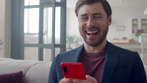 business man laughing with phone at home