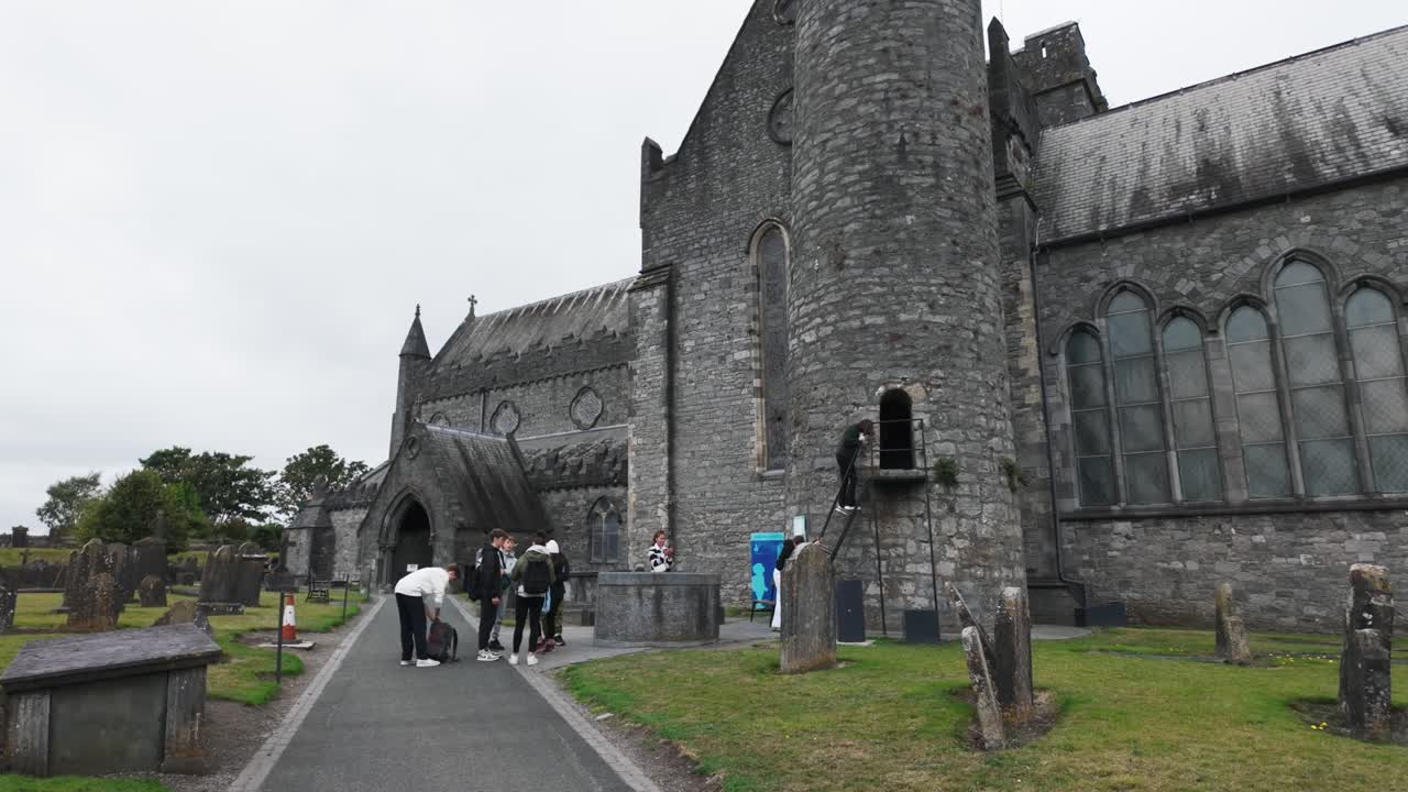 Ireland epic Locations tourists visiting the ancient round tower at St Canices Cathedral Kilkenny City Ireland