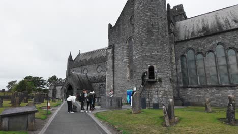 ireland epic locations tourists visiting the ancient round tower at st canices cathedral kilkenny city ireland