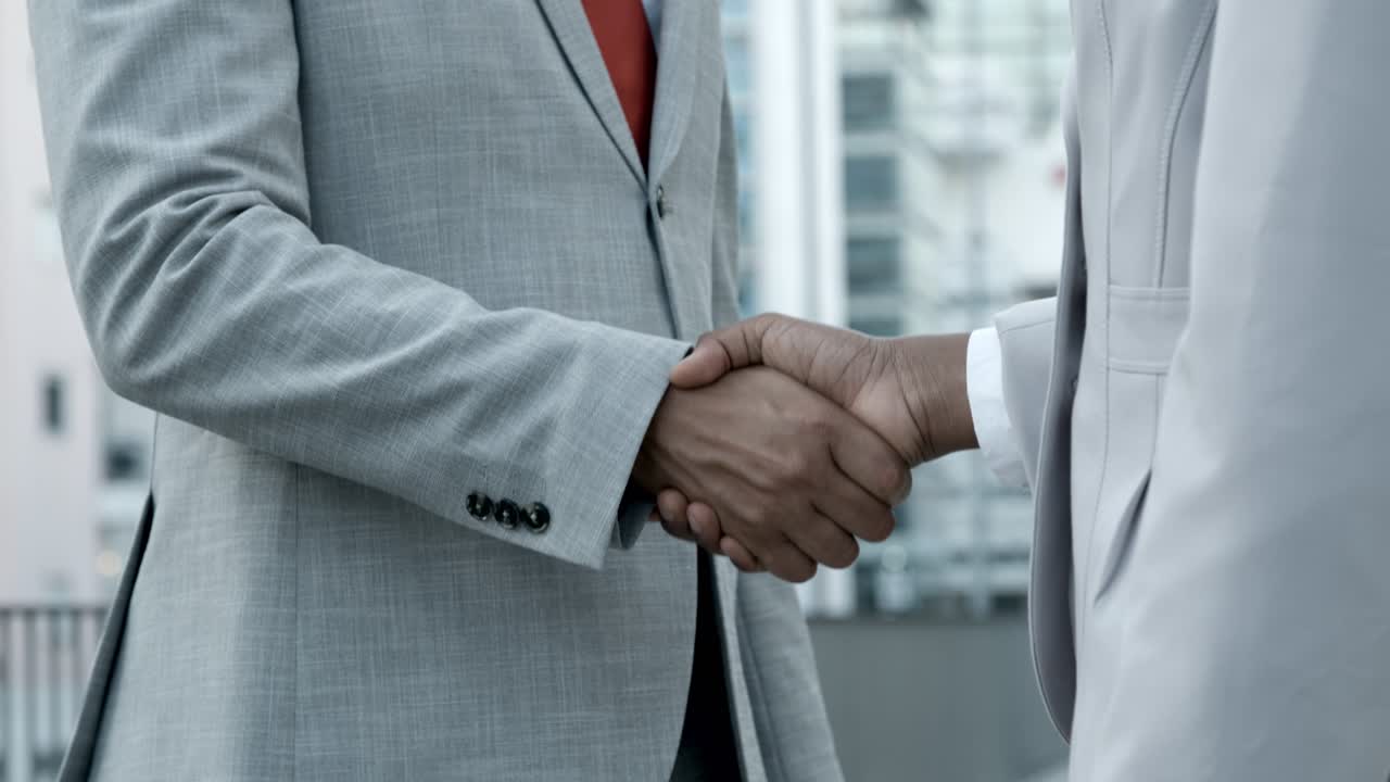African American colleagues shaking hands on street