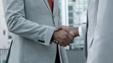 african american colleagues shaking hands on street