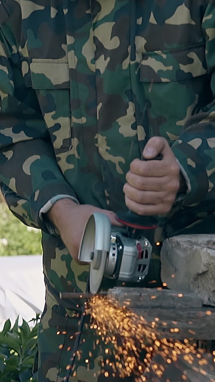 Person in Camouflage Uniform Using Angle Grinder