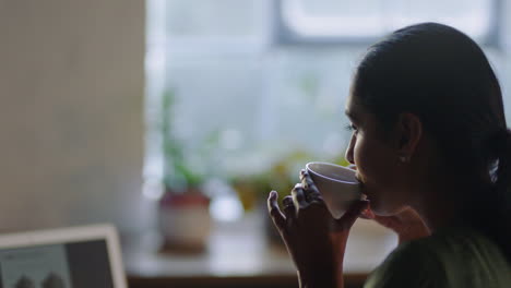 young-indian-business-woman-using-laptop-computer-in-cafe-drinking-coffee-typing-email-messages-working-late-sharing-networking-ideas-enjoying-online-social-media-communication