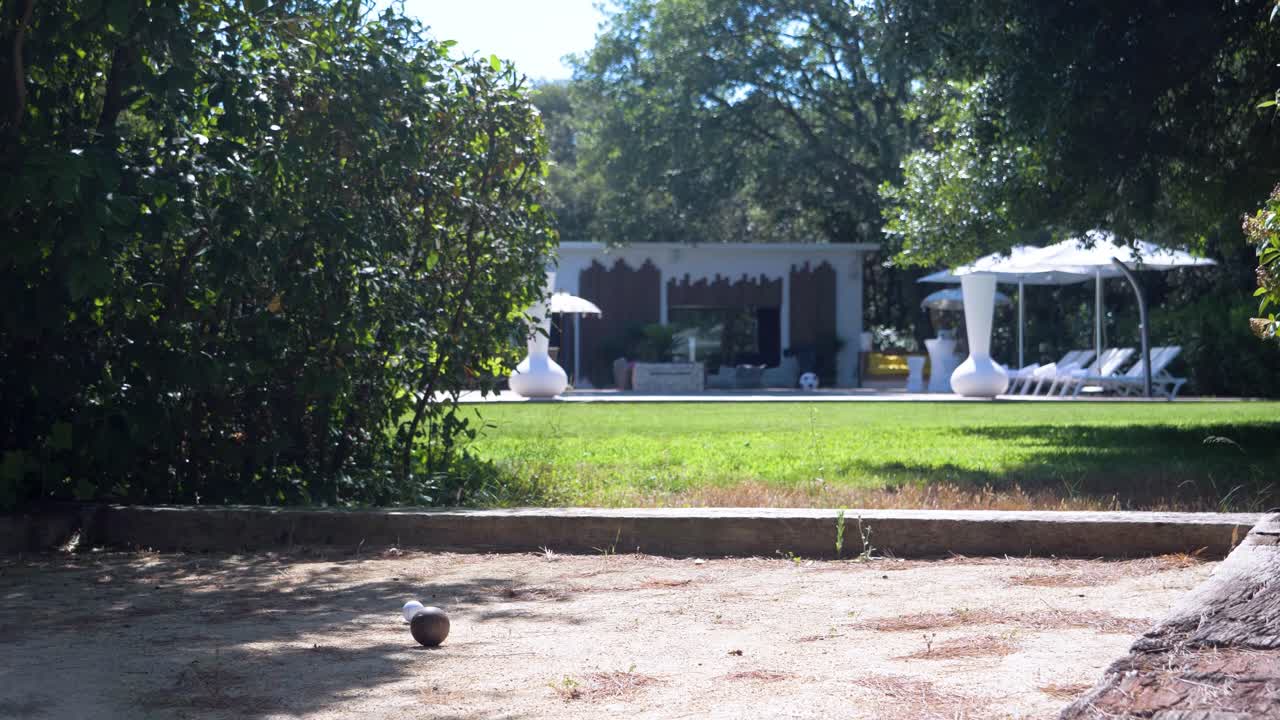 Slow motion shot of bowls hitting off of each other in a garden