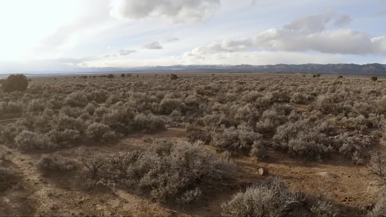 panorámica aérea y toma de barrido del valle del desierto que termina con montañas lejanas en utah