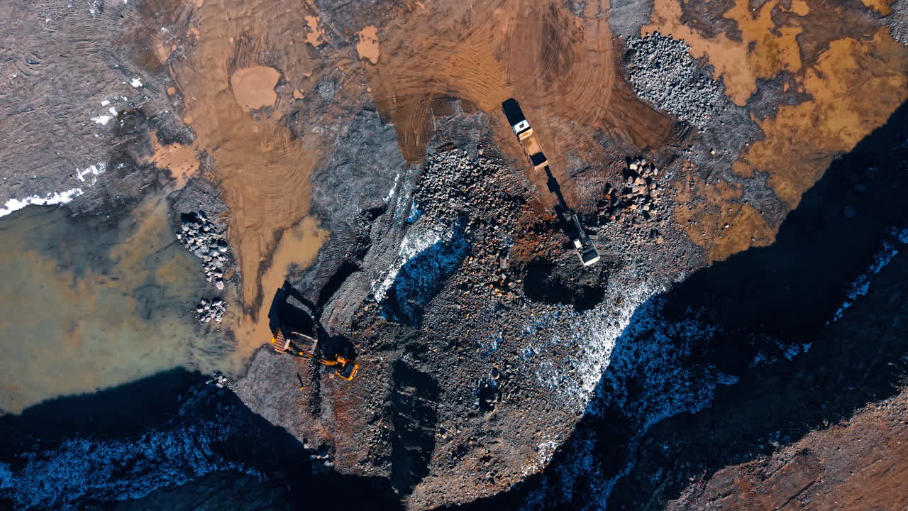 Active site with heavy machinery. Heavy machines operate at a construction site. Workers move earth and materials