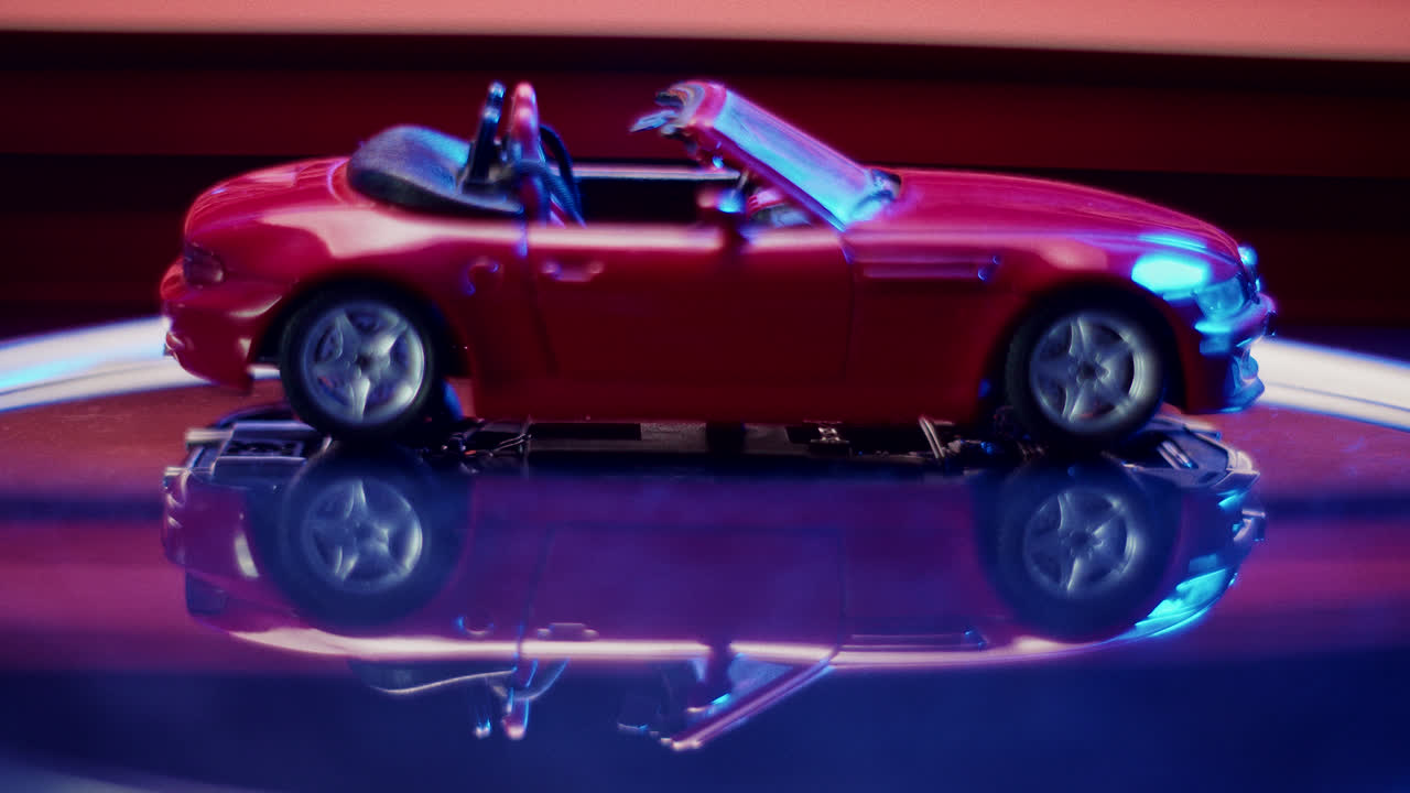 Red Toy Convertible Car with Reflective Surface and Neon Lighting