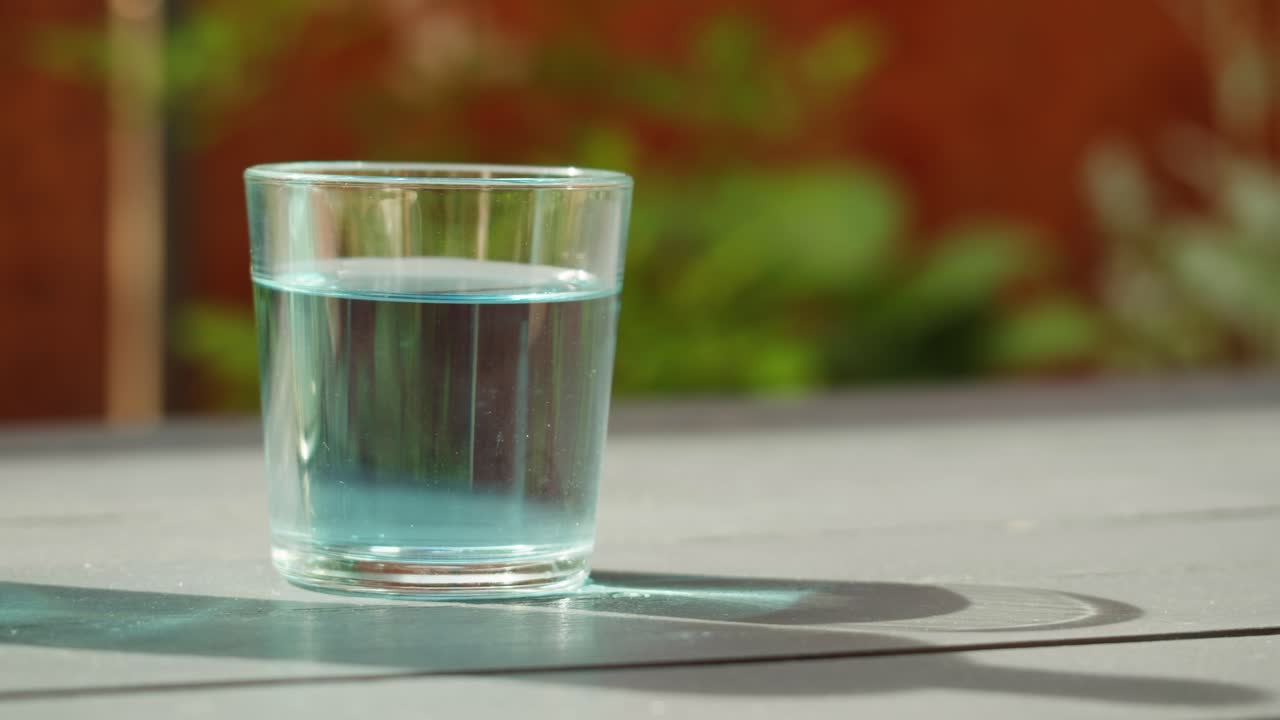 Glass of Blue Water on a Table