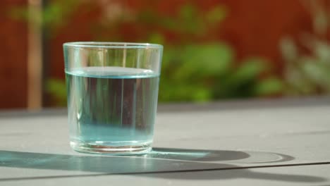 glass of blue water on a table