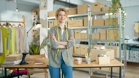 caucasian young tailor woman in good mood looking at camera and smiling in clothing store