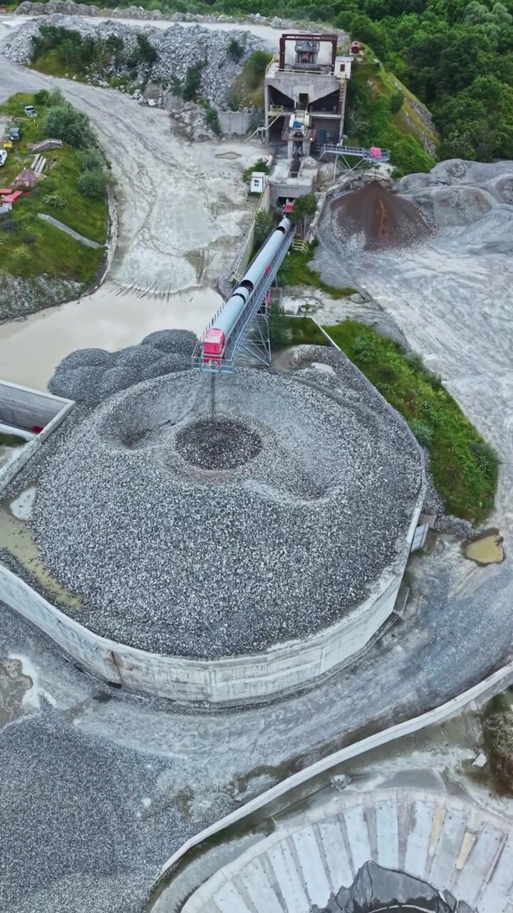 Granite quarry site with machinery and stockpiles during daylight hours in an operational setting in nature