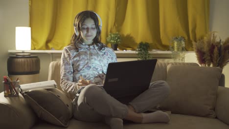 male student listening to music and studying at night.