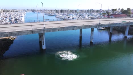 Antena-Sobre-Tres-Hombres-Jóvenes-Que-Saltan-Al-Puerto-De-Oxnard-Desde-Un-Puente-De-California