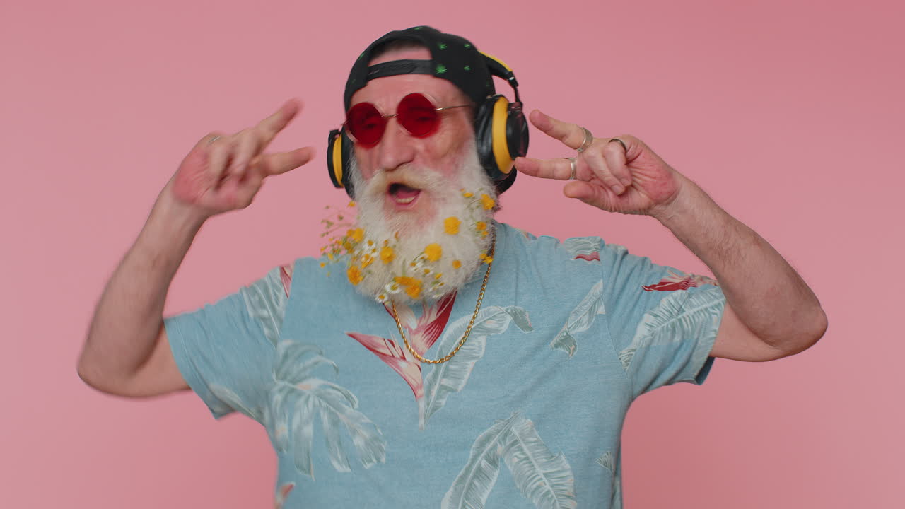 hombre alegre y atractivo escuchando música a través de auriculares y bailando discoteca burlándose de divertirse