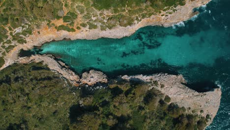 Clear-turquoise-blue-sea-water-and-white-sand-beach-at-a-remote-natural-bay,-Palma-de-Mallorca-Island