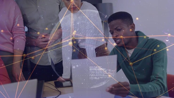 Seated man holding paper initiating tech data review with team, data overlay appearing over sheets