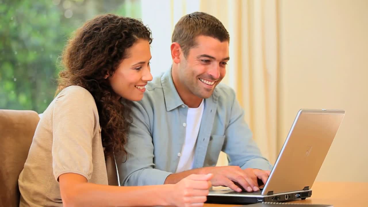 Pareja joven jugando a un juego en un portátil