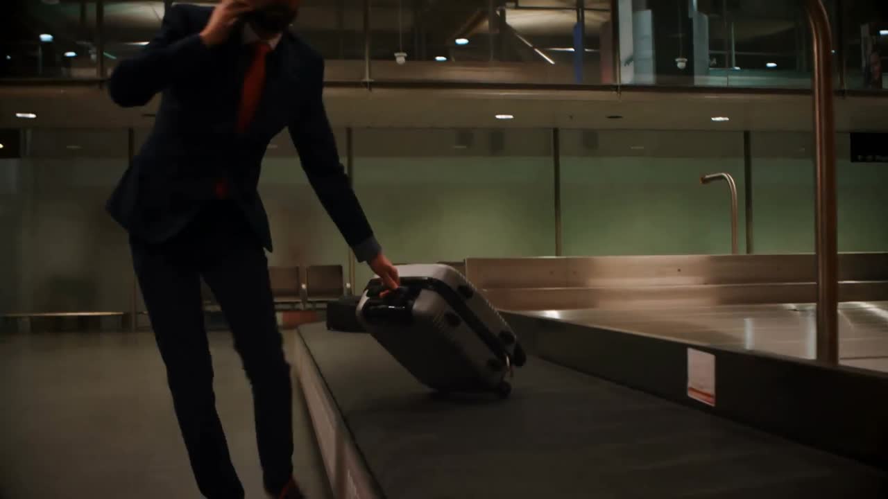 Businessman picking his luggage from baggage claim area 4k