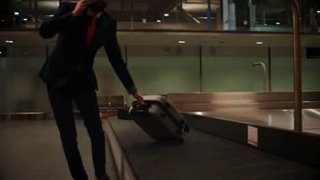 Businessman-picking-his-luggage-from-baggage-claim-area-4k