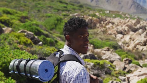 Portrait-of-african-american-man-exercising-outdoors-hiking-in-countryside-on-a-mountain