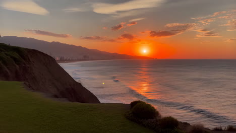 vibrant orange sunset over the ocean from a coastal cliff