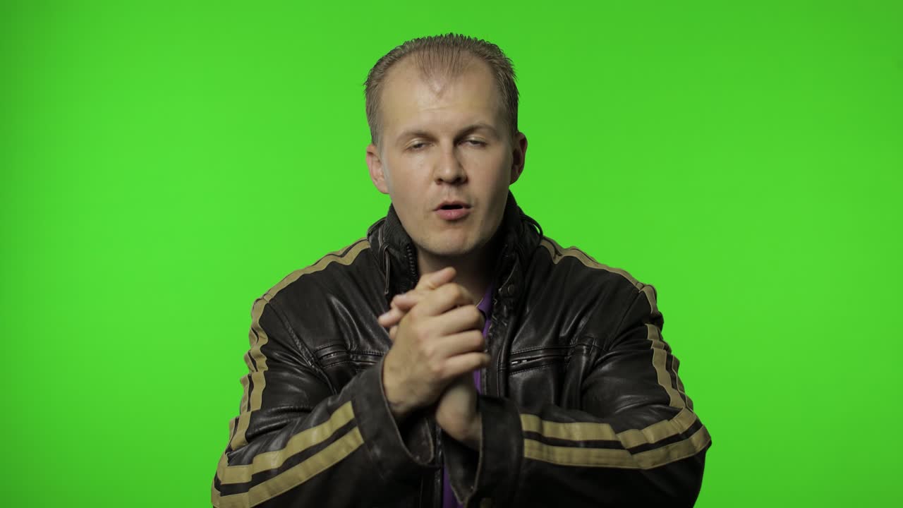 hombre rocker feliz en chaqueta de vaqueros marrón aplaudiendo las manos y mirando con expresión facial orgullosa