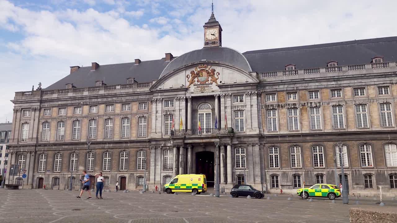 Yellow rescue paramedic first responder ambulances with emergency lights flashing passing The Prince-Bishop palace in the city of Liege, Belgium