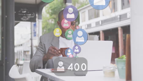 animation of people digital icons over man having coffee and using laptop