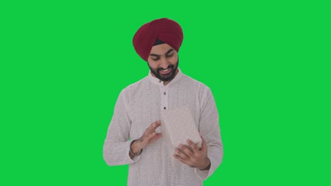 hombre indio sikh feliz recibiendo un regalo pantalla verde