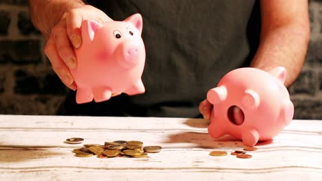 emptying two piggy banks with unequal shares of money, financial concept