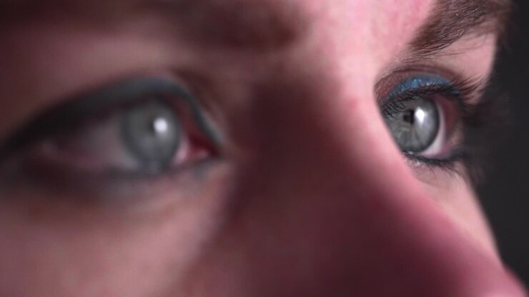 Reflection of screen on person's blue green eye in dark room 20